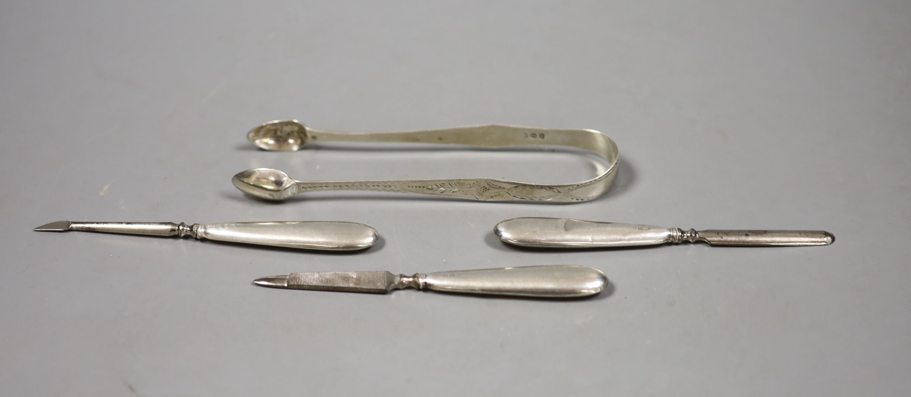 A pair of sugar tongs and three manicure implements